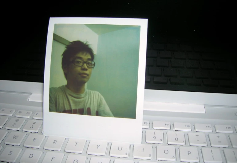 a polaroid pograph placed next to a computer keyboard