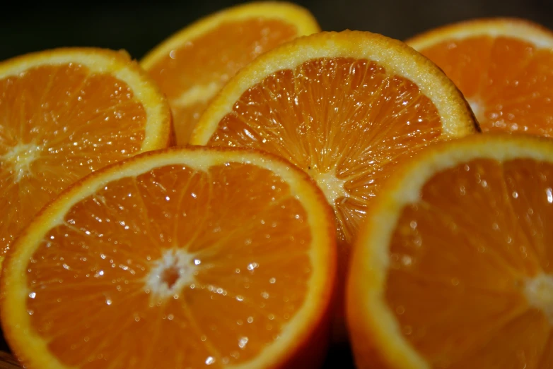 a number of oranges on a tray with water on them