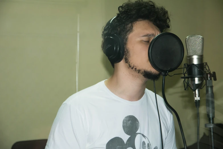a person with headphones on singing into a microphone