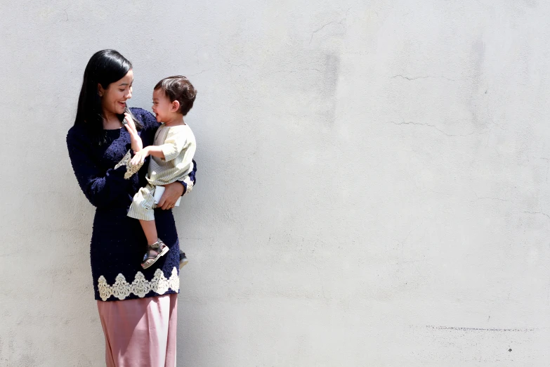 a woman is holding a baby in her arms