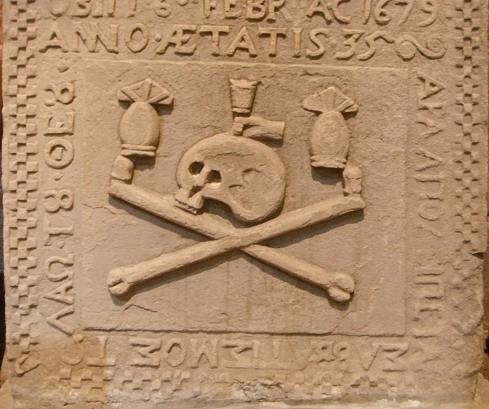 a stone memorial with two skulls, axes and axes