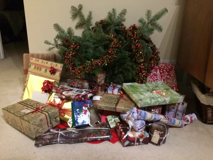 christmas presents are piled up by the christmas tree