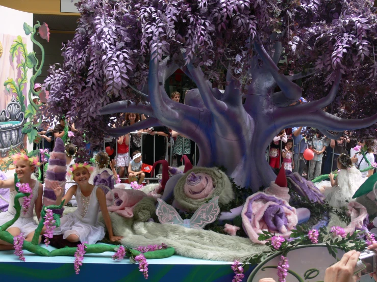 several people sitting in front of a tree in a parade