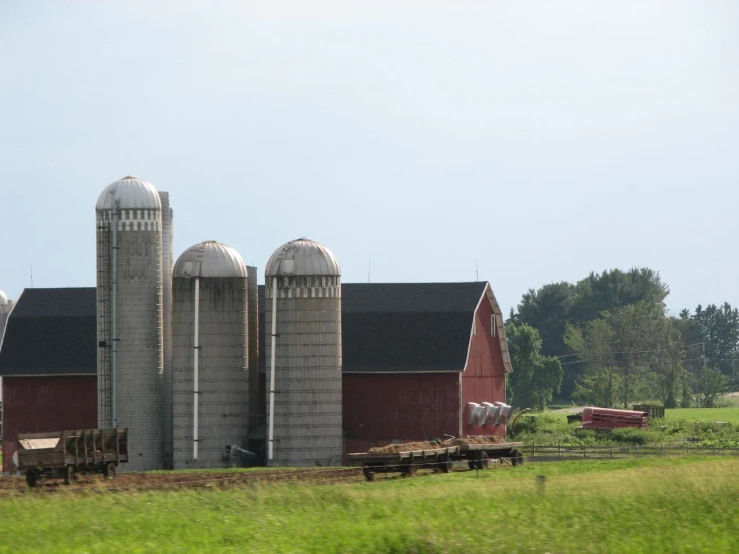 farm equipment is parked outside a barn