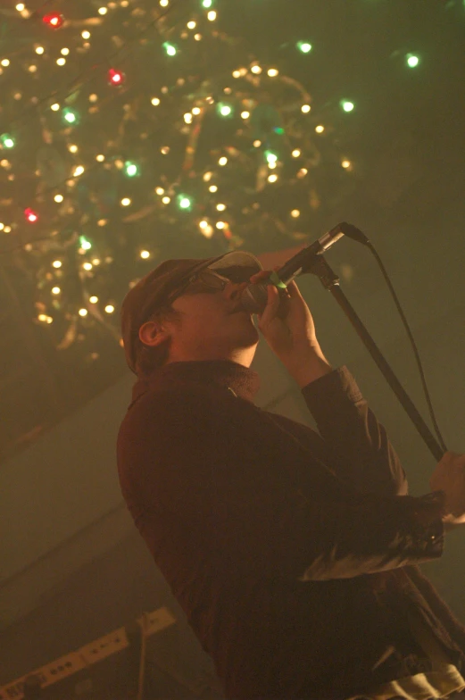 a man in dark clothes singing into a microphone