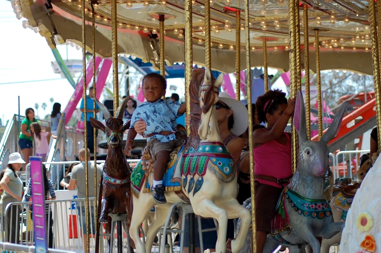 children enjoying the merry go round in a park