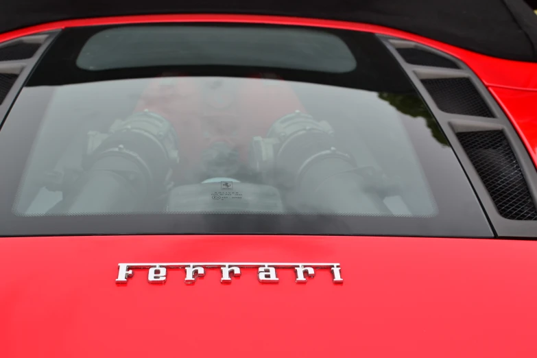 the reflection of a man behind a window of a red car