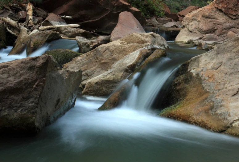 a mountain stream running between rocks and trees