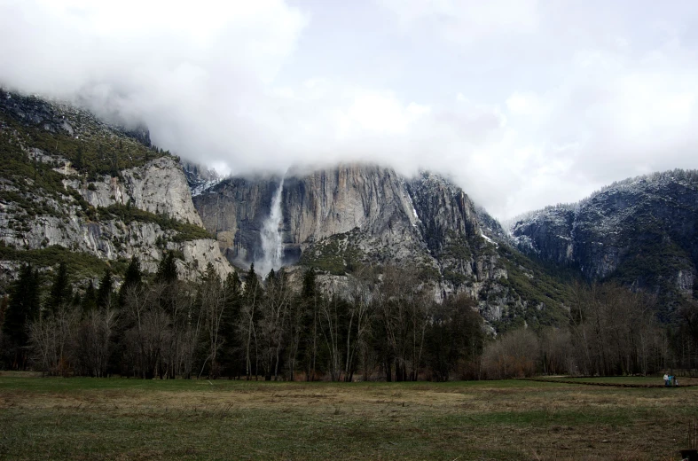 a large mountain is in the background with mist coming from it