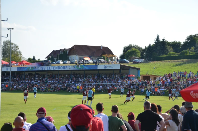 several people standing on a field playing soccer