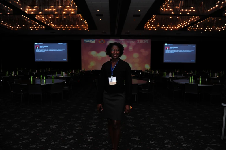 a woman in a suit standing in front of a screen