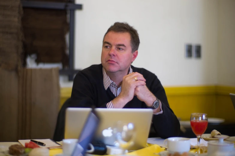 man sitting at a table in front of a laptop