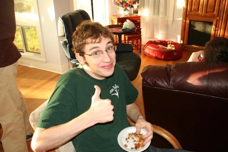 a young man gives a thumbs up in his living room