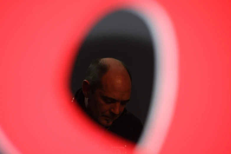 a man looking in to a circular object