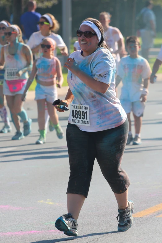 a woman is running in a race with many colors