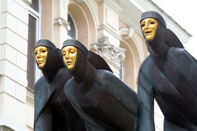 three large sculptures that have faces in them