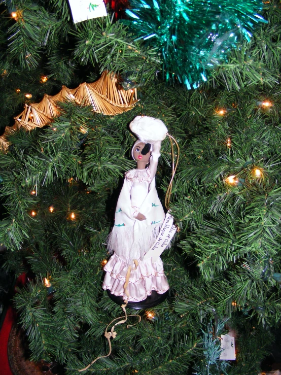 a small white doll in a tree by itself