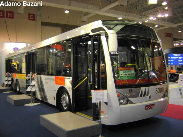 a white bus on display in a building