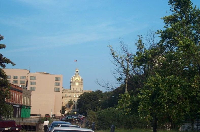 cars parked on the side of a road with buildings in the background