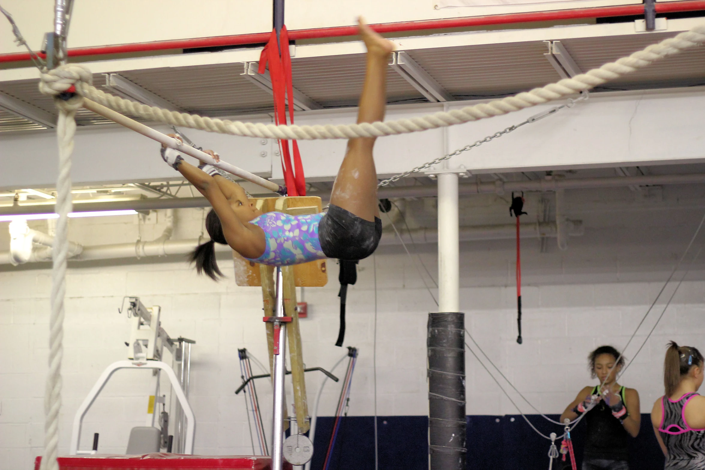 a woman is climbing on a rope while another watches