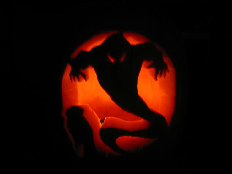 a scary picture of someone on a lizard carved pumpkin