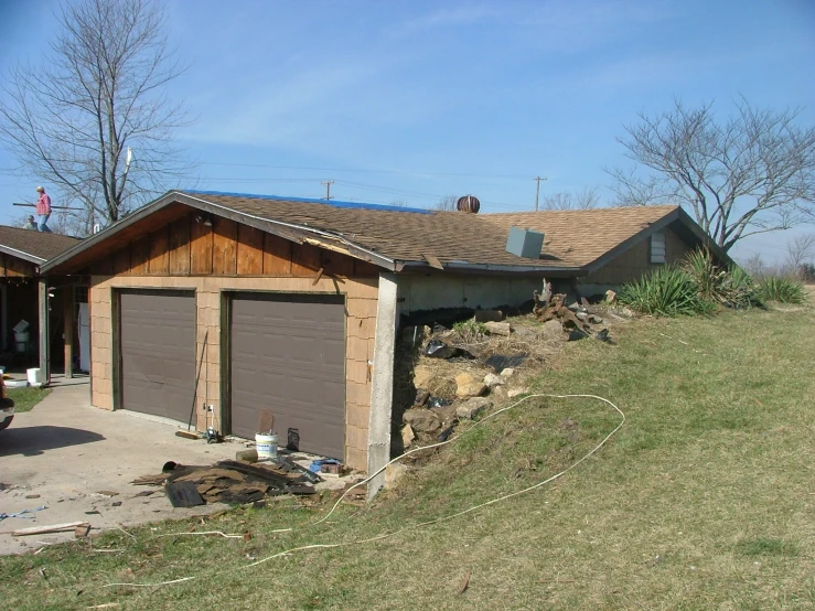 a yard with a grass covered hill next to the house