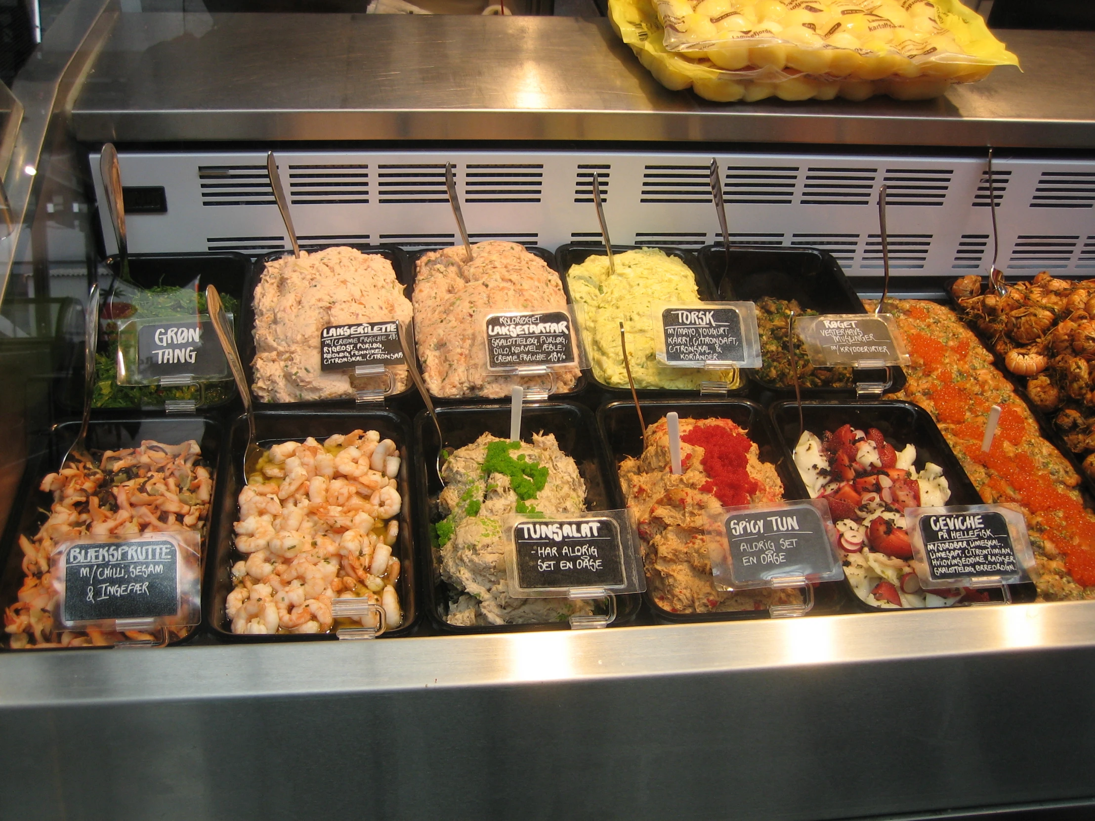 assorted foods sitting in a display case at a deli