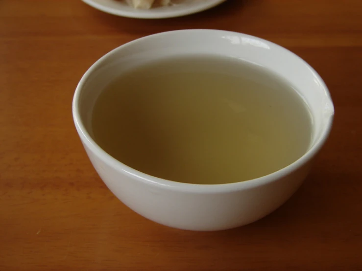 a bowl with green tea next to a spoon