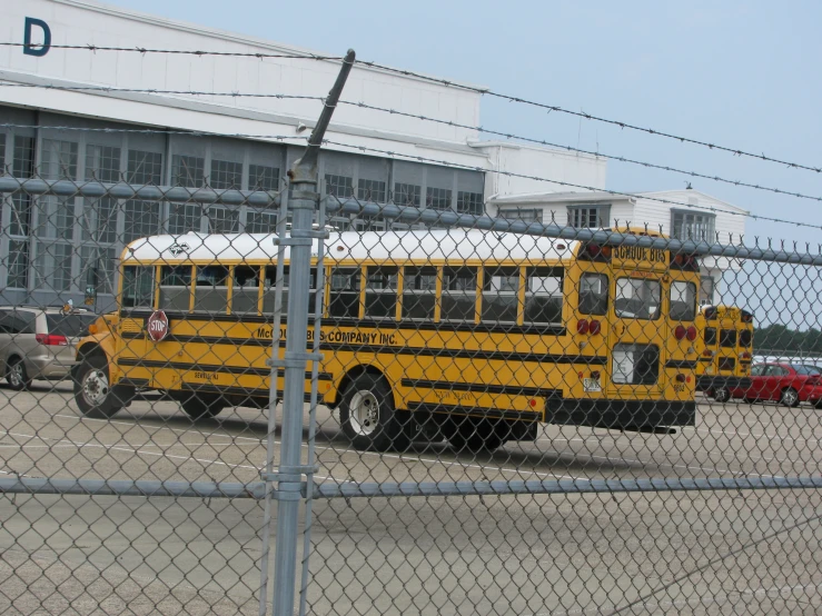 two school buses parked side by side next to a fence
