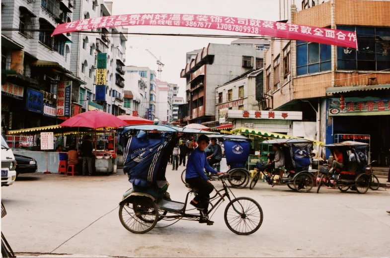 a man riding on top of a bike under an umbrella