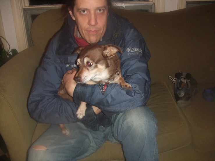 a man holds his dog in the arms