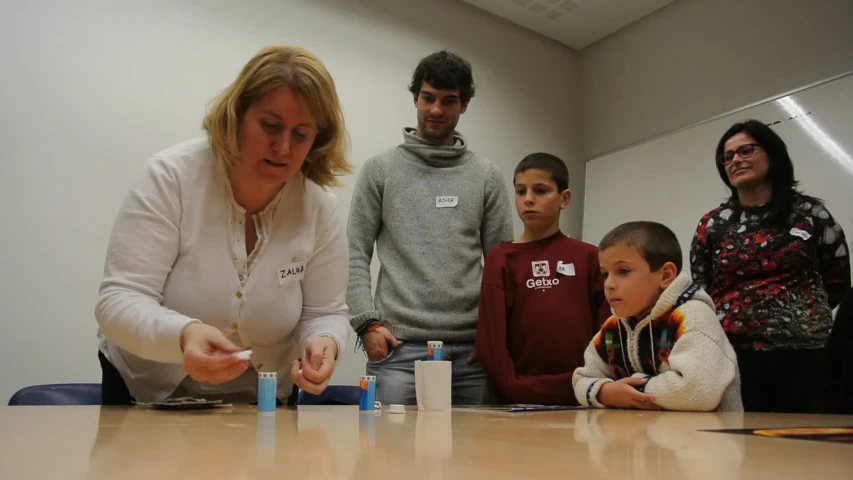 a group of people and children watching a woman set up match