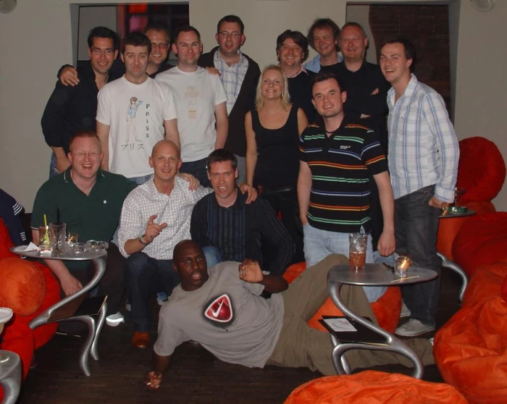 a group of people are posing for a po while holding onto small trays