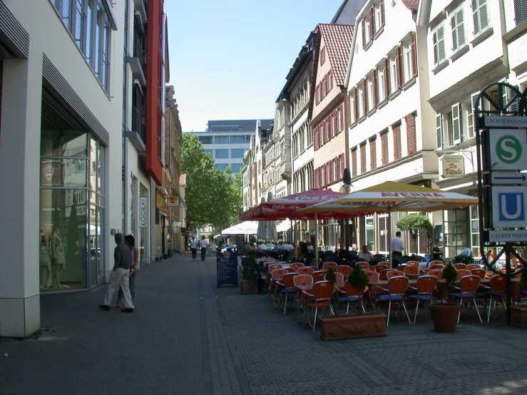 an outdoor cafe on a street near many stores