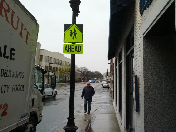 there is a man walking in the street near a bus stop