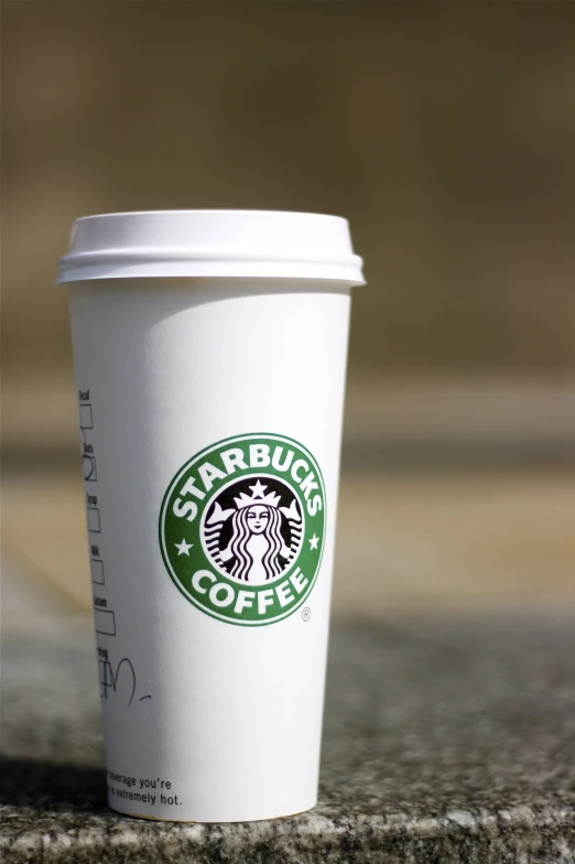 a starbucks cup sitting on the ground