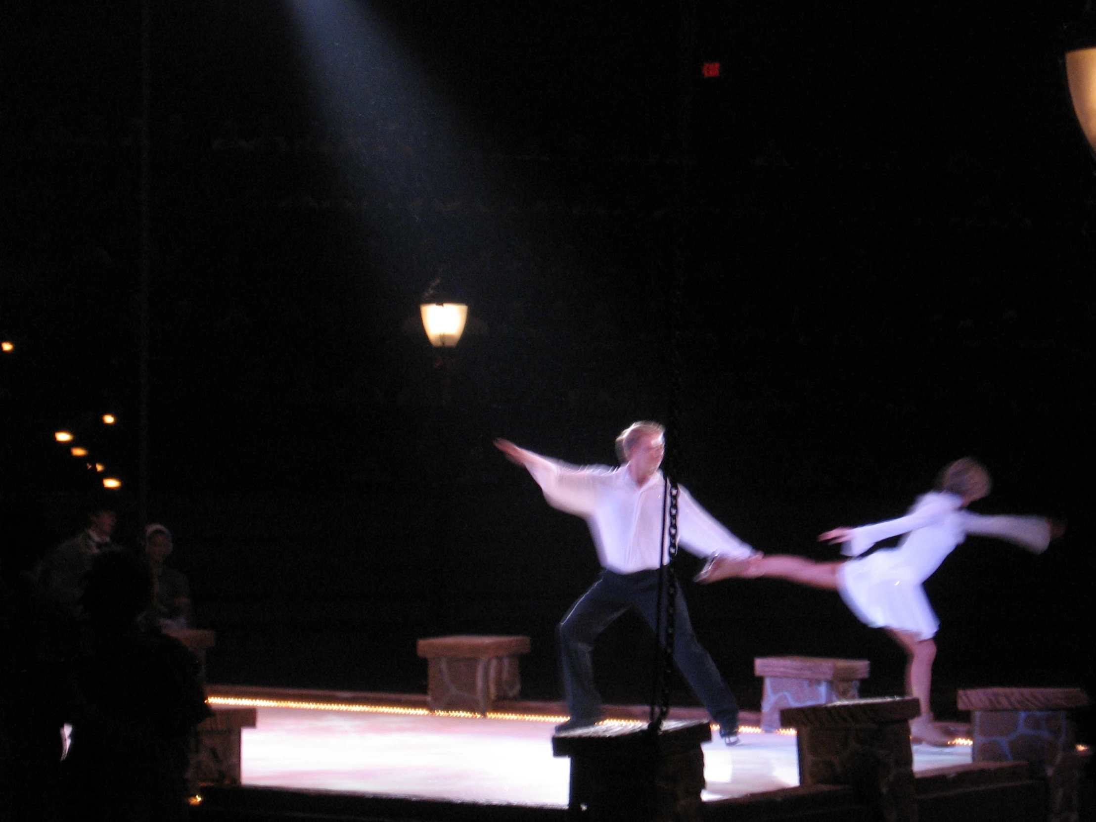 two people dressed in white performing a dance