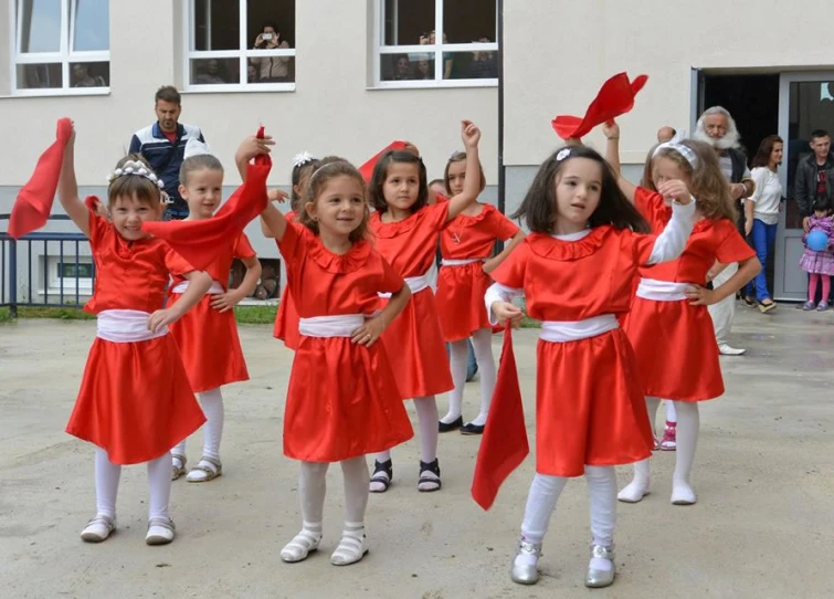 a group of children dressed in bright red robes