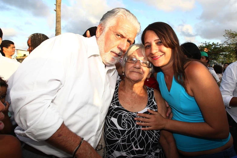 two women and an older man posing for the camera