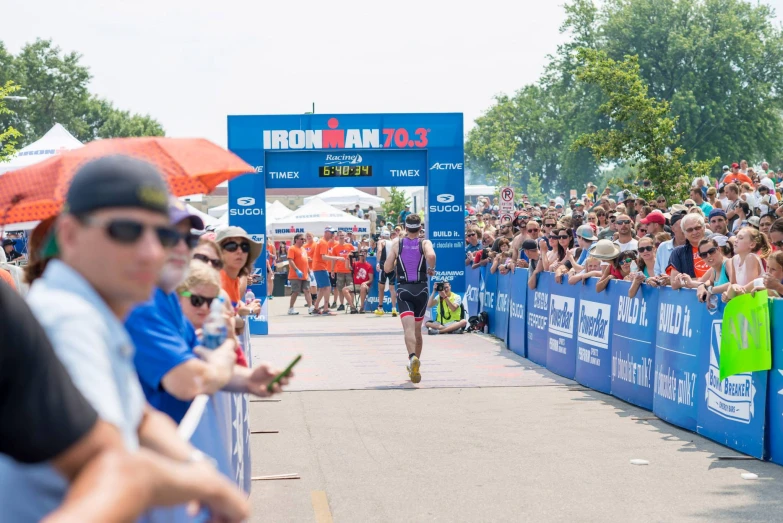 a man is running down the marathon route with many people watching