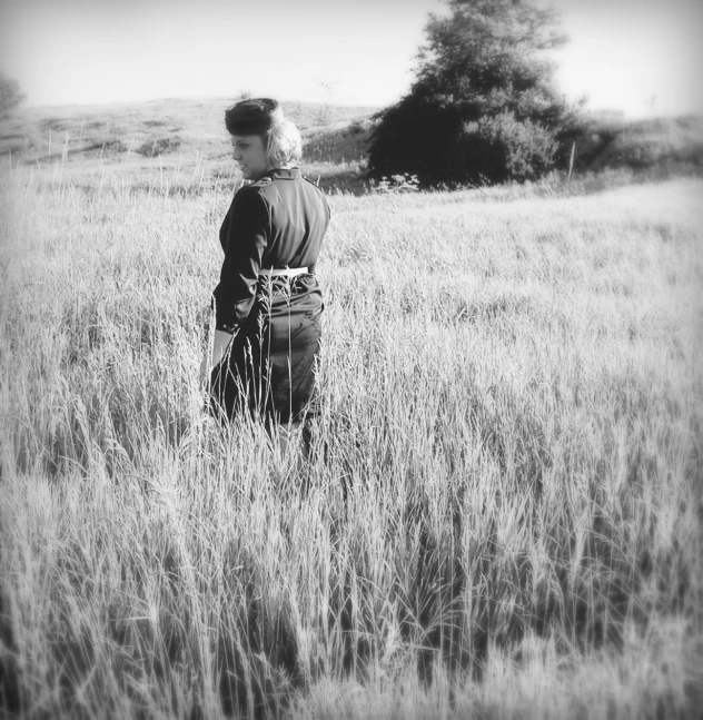 a man in the middle of an open field with a suitcase