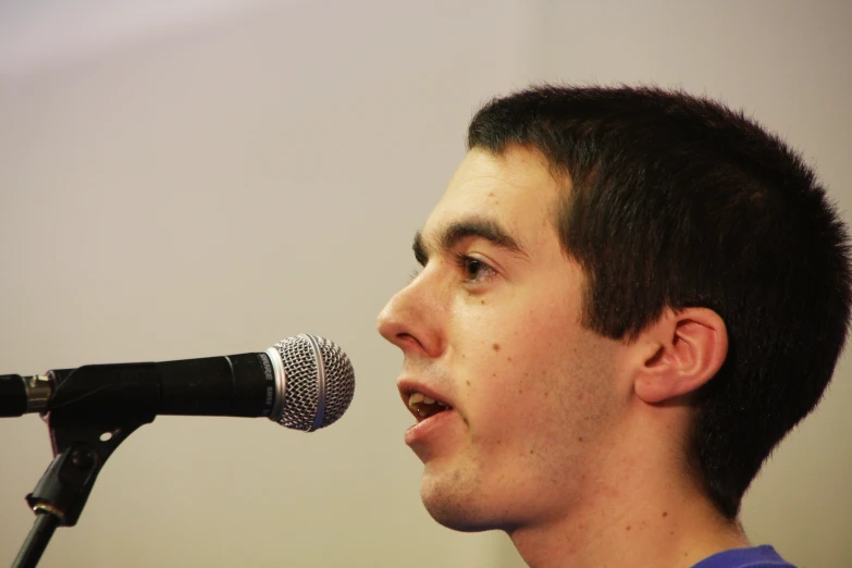 man holding up microphone to hear soing from it