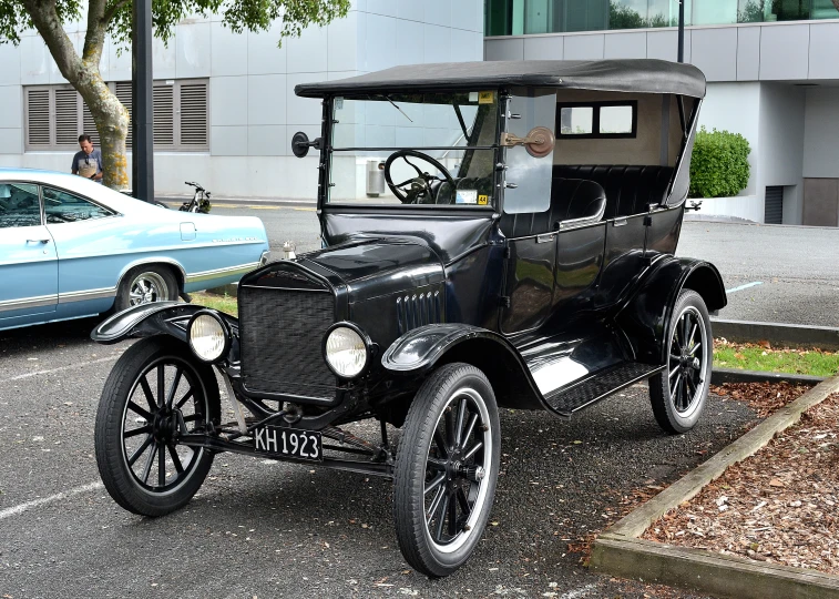 an old car parked in a parking lot next to two cars