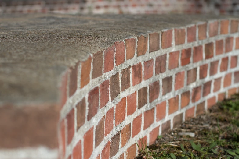 a bricked wall with grass growing out of it