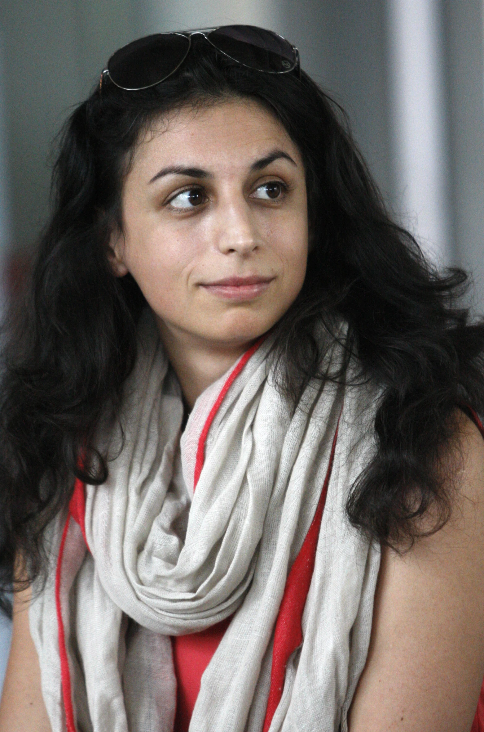 a woman with sunglasses and a white scarf around her neck