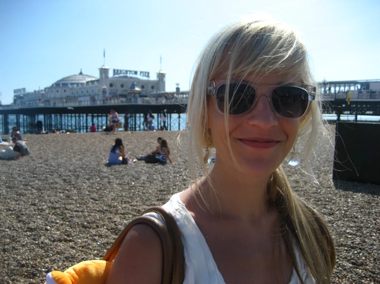 a woman standing on the beach in front of a building