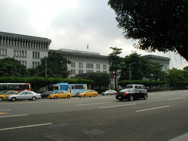a city street with yellow taxi cabs in front of an executive building