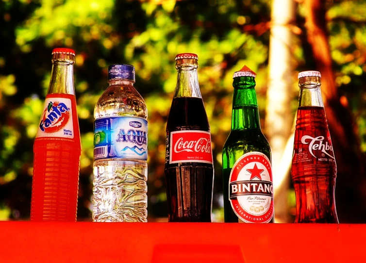 several bottles of soda, beer and water sitting on a table