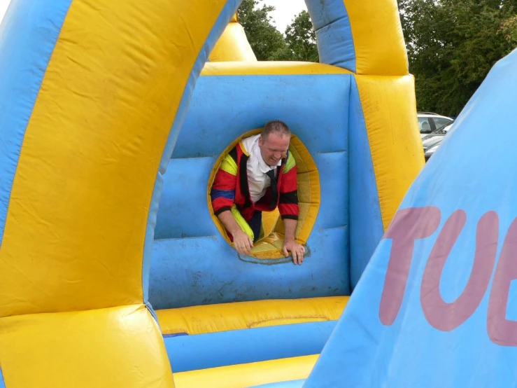 a man leaning down in an inflatable tunnel