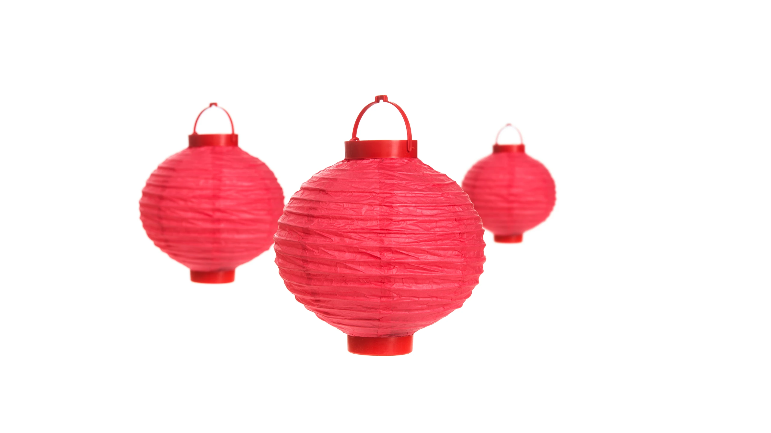 three pink round paper lanterns hung on string